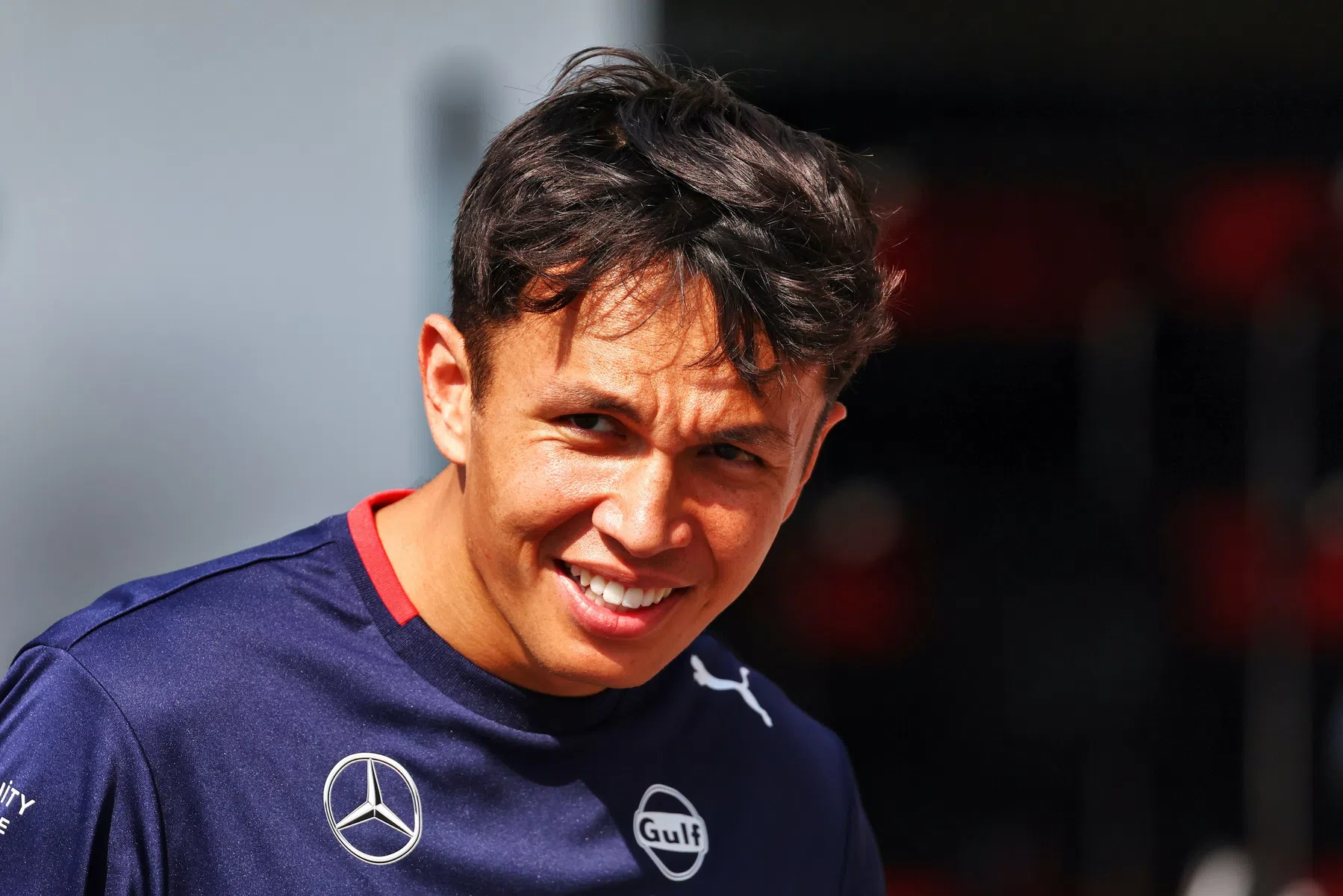 F1 driver Alexander Albon reacts to Adrian Newey at Aston Martin